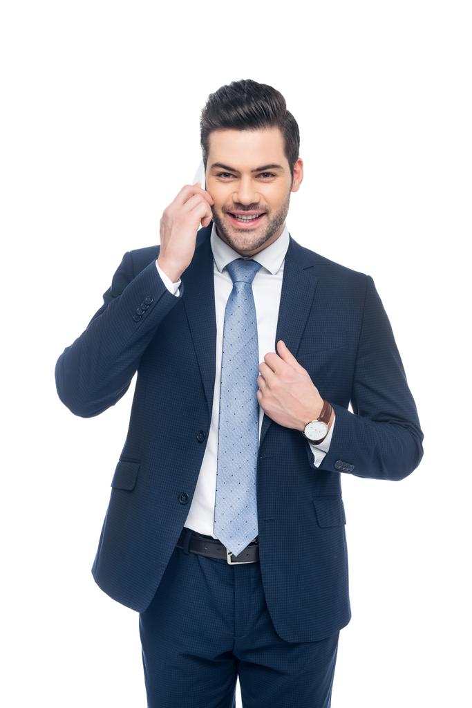 красивый улыбающийся бизнесмен в костюме, разговаривающий на смартфоне, изолированный на белом
 - Фото, изображение