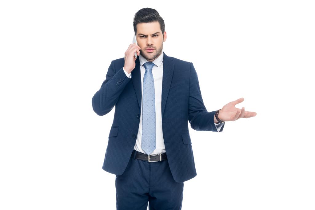сомнительный бизнесмен в костюме разговаривает на смартфоне, изолированный на белом
 - Фото, изображение