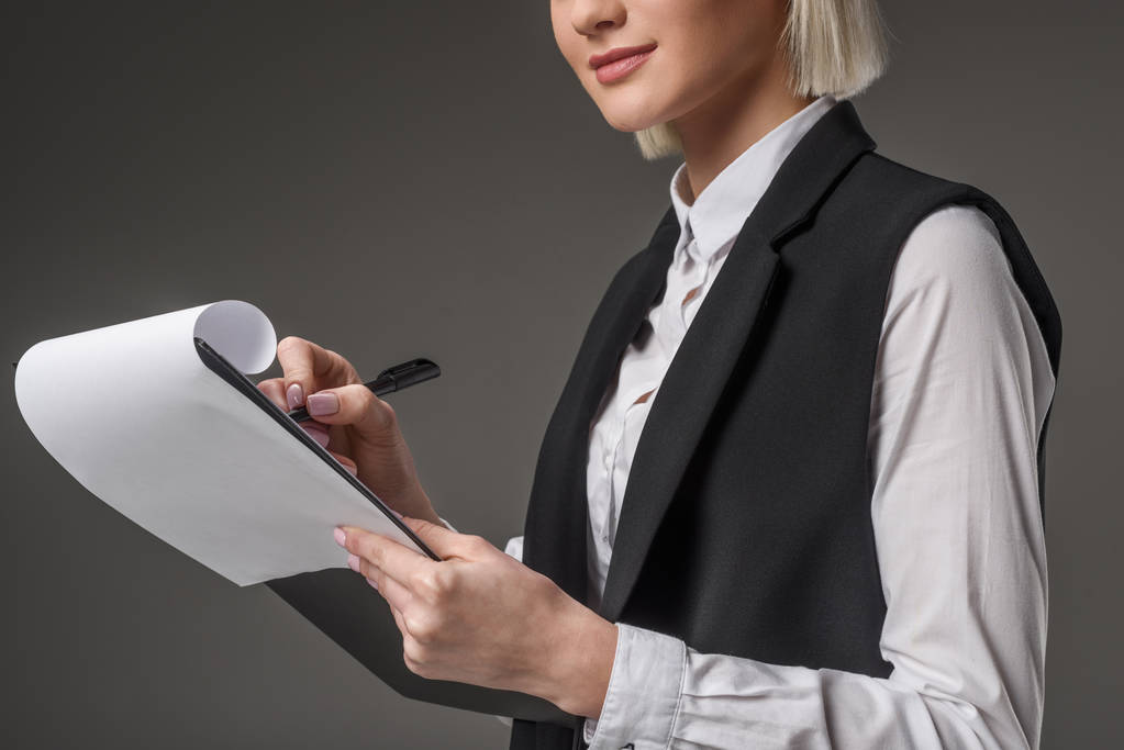 частковий вид бізнес-леді з блокнотом ізольовано на сірому
 - Фото, зображення