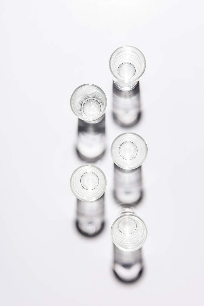 beş küçük boş bardak beyaz masa üzerinde yukarıdan - Fotoğraf, Görsel