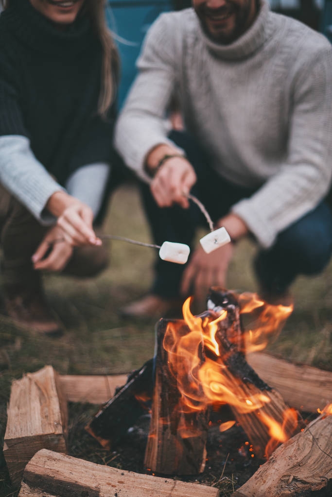Casal jovem bonito assar marshmallows sobre uma fogueira
  - Foto, Imagem