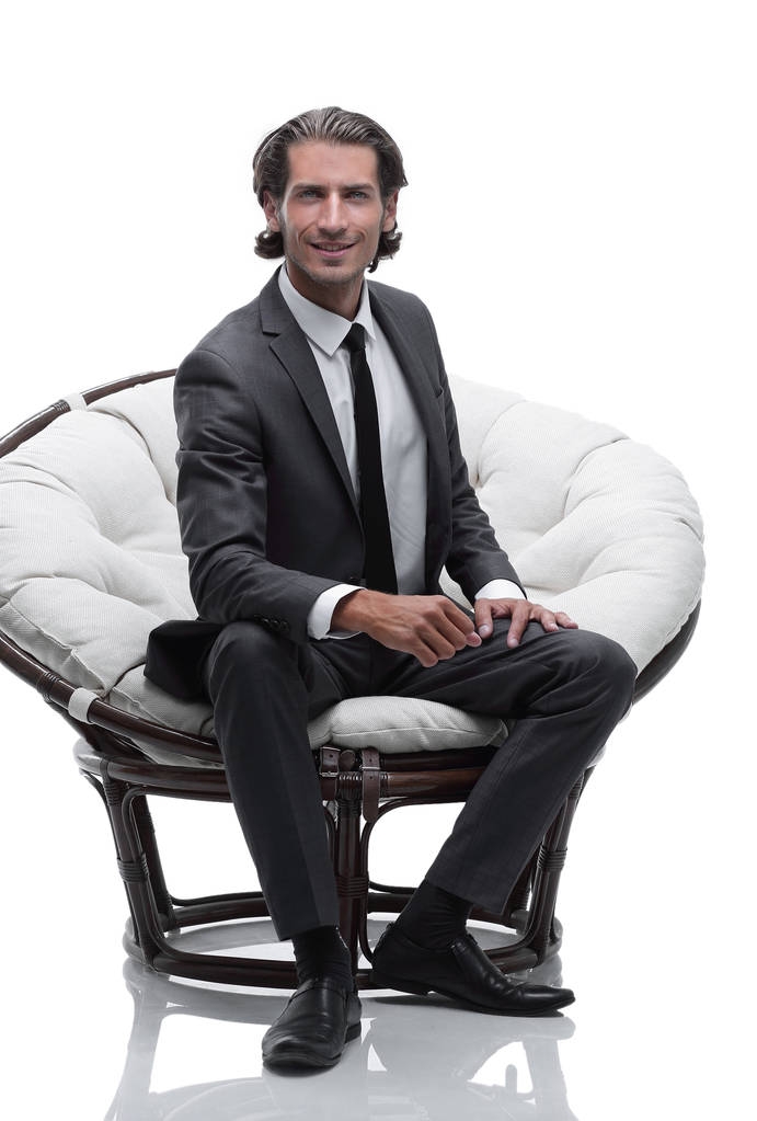 liikemies istuu mukavassa isossa tuolissa
 - Valokuva, kuva