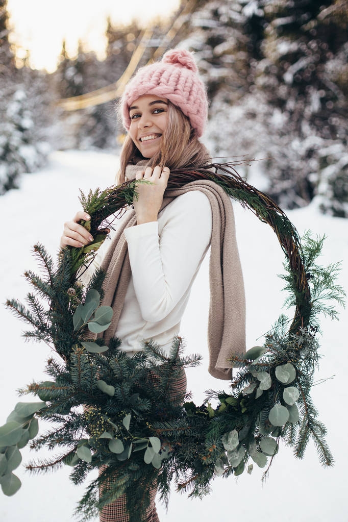 冬の森のクリスマス リースと金髪の若い女性 - 写真・画像