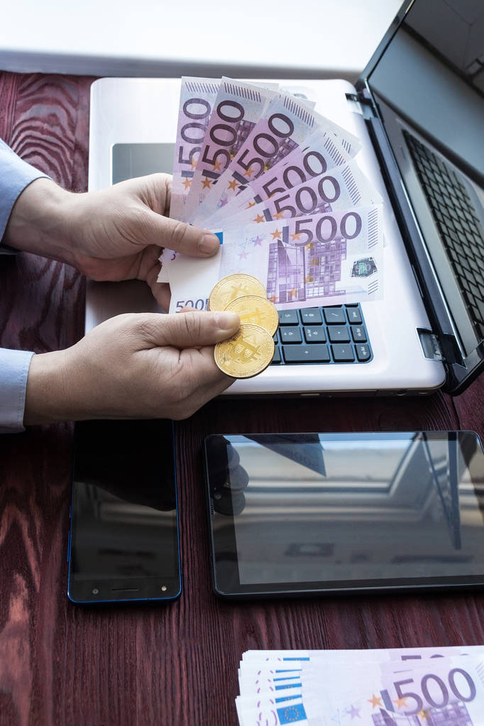 Laptop com dinheiro e bitcoin
 - Foto, Imagem