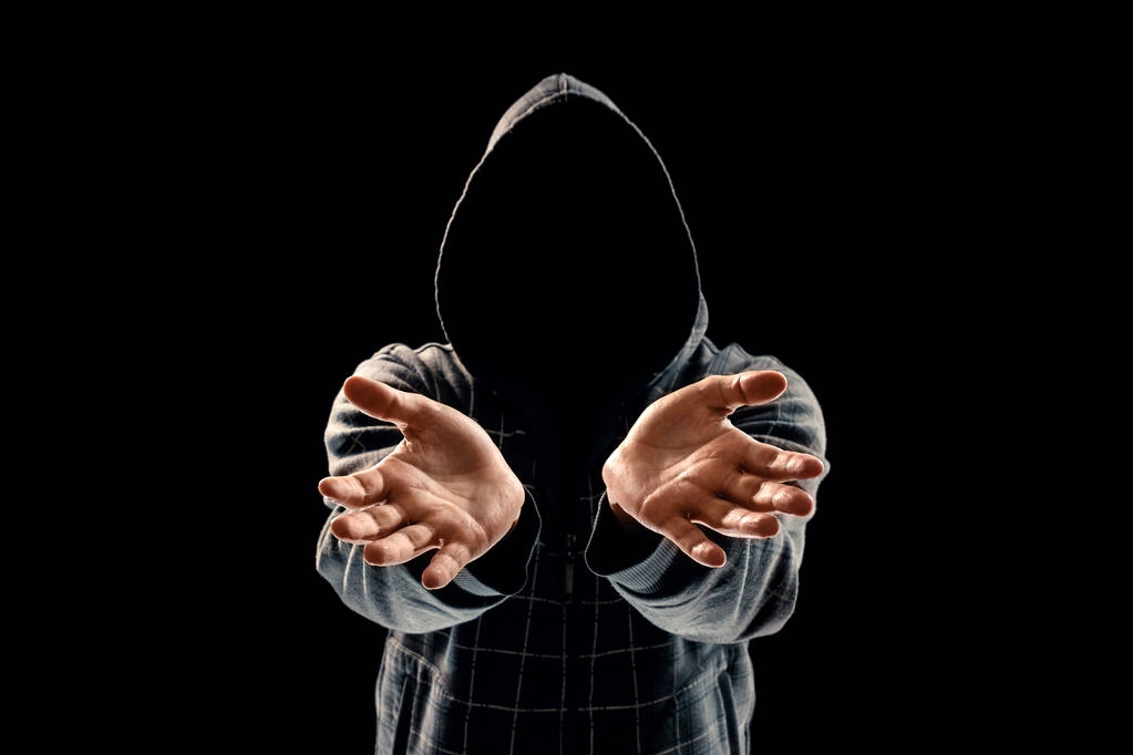 Silhouette di un uomo in cappuccio su sfondo nero, il volto non è visibile, mostra i palmi della fotocamera. Il concetto di criminale è dato, in incognito, segreto, segreto, anonimato
. - Foto, immagini