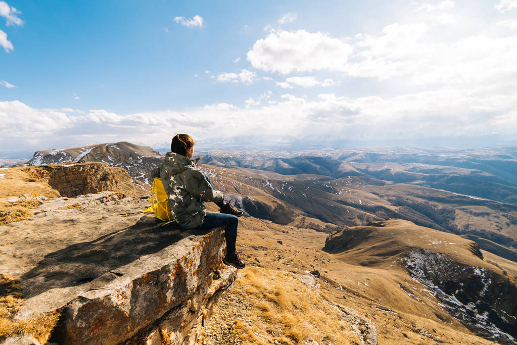 τουριστική γυναίκα κάθεται στο φόντο των βουνών - Φωτογραφία, εικόνα
