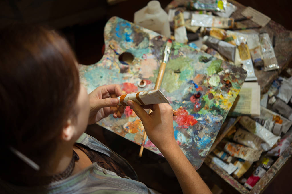 Mladá žena umělec Malování s olejovými barvami v dílně studio - Fotografie, Obrázek