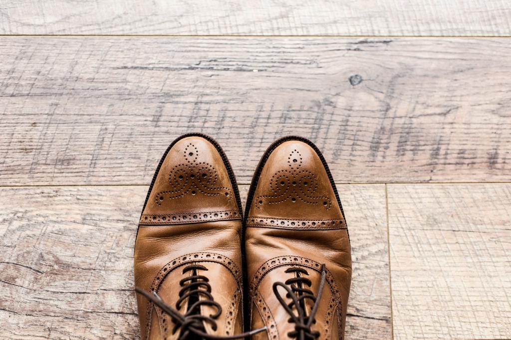 top view of pair of leather brown shoes on wooden floor - Photo, Image