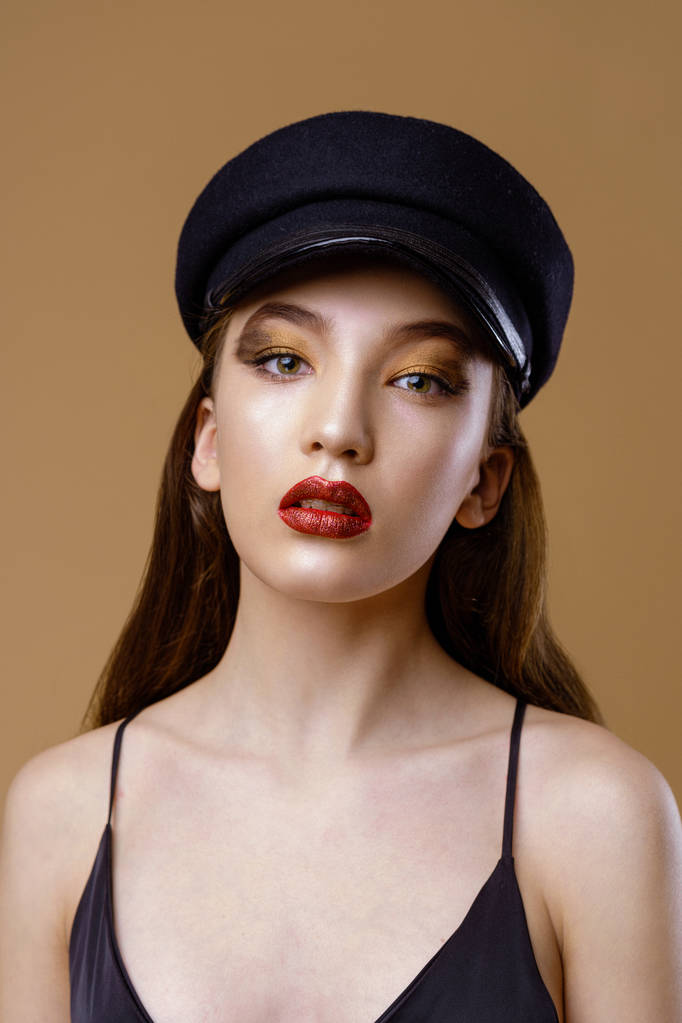 Portrait de magnifique jeune mannequin en chapeau posant sur fond de studio
  - Photo, image