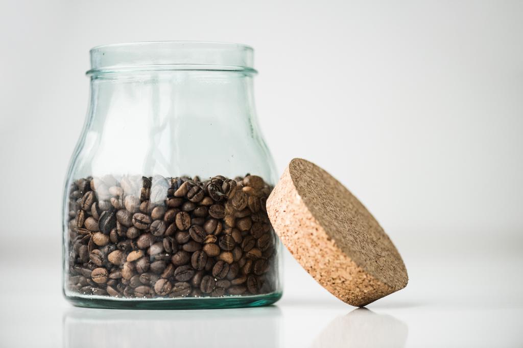 botella de vidrio con granos de café y corcho en blanco
 - Foto, Imagen
