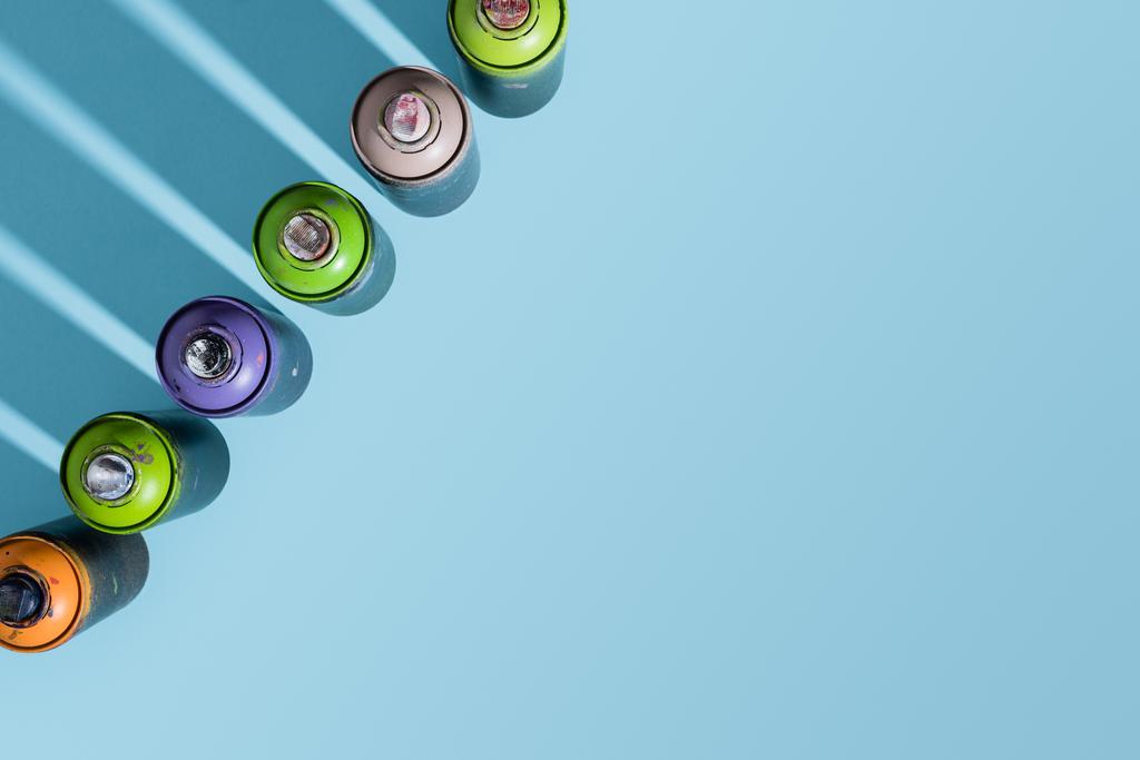 top view of arranged cans with aerosol paint isolated on blue - Photo, Image