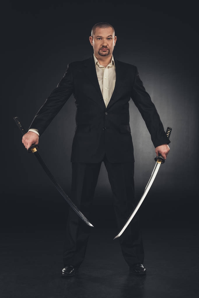 mężczyzna w kostiumie z Mieczami dual katana na czarny - Zdjęcie, obraz
