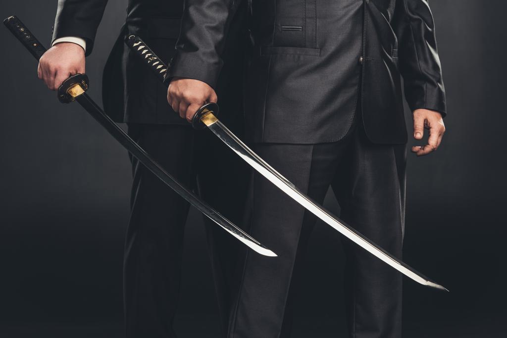 cropped shot of modern samurai with katana swords isolated on black - Photo, Image