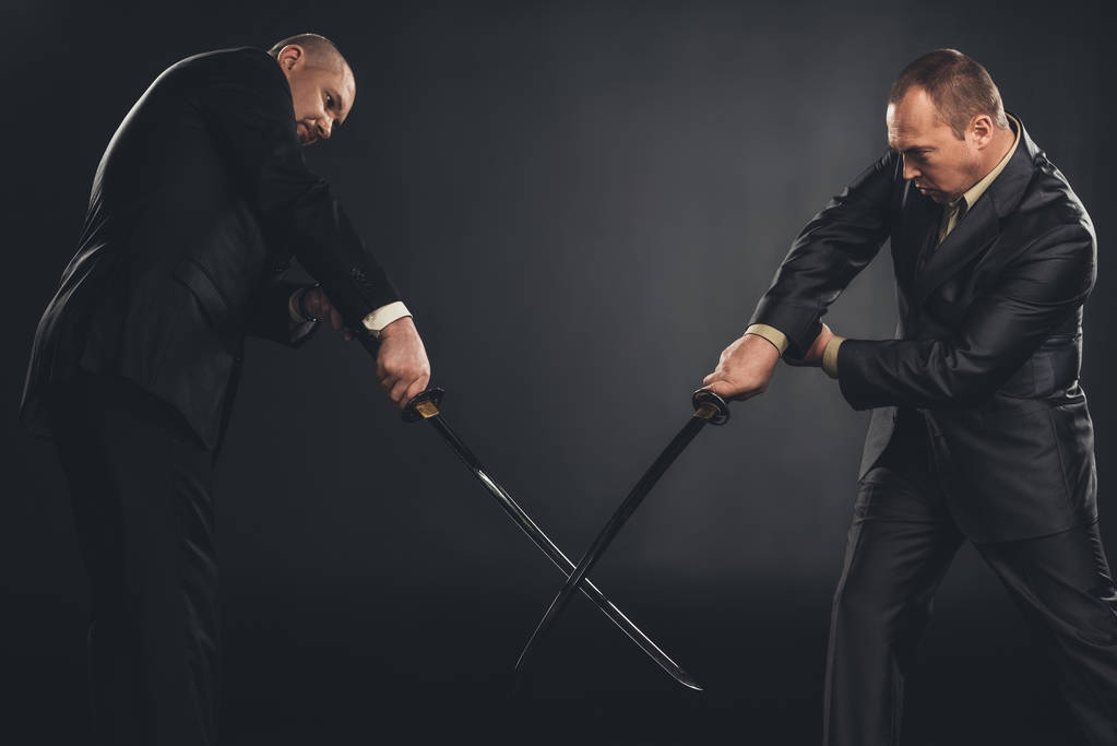 homens de negócios lutando com espadas de katana isolados em preto
 - Foto, Imagem