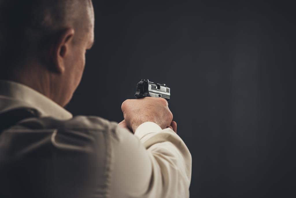 Close-up shot van veiligheid man gericht met pistool - Foto, afbeelding