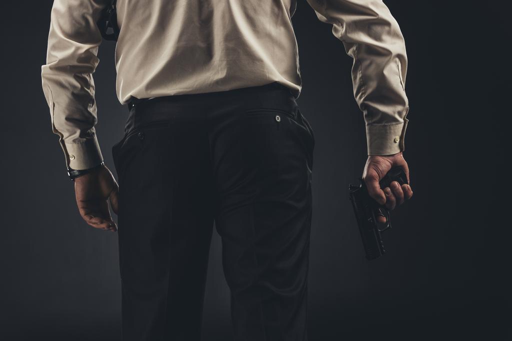 tiro cortado de homem segurando arma na mão
 - Foto, Imagem
