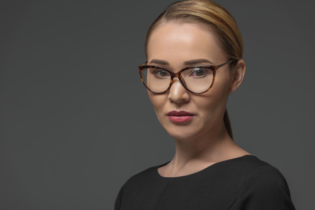 close-up portrait of beautiful kazakh woman in spectacles looking at camera isolated on grey  - Photo, Image