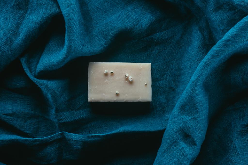 Draufsicht auf natürliche hausgemachte Seife auf dunkelblauem Leinen - Foto, Bild