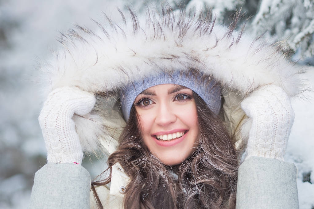Porträt einer lächelnden jungen Frau mit langen Haaren im Winter - Foto, Bild