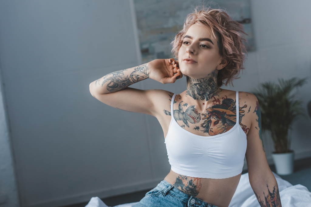beautiful stylish inked girl stretching in bed at morning - Photo, Image