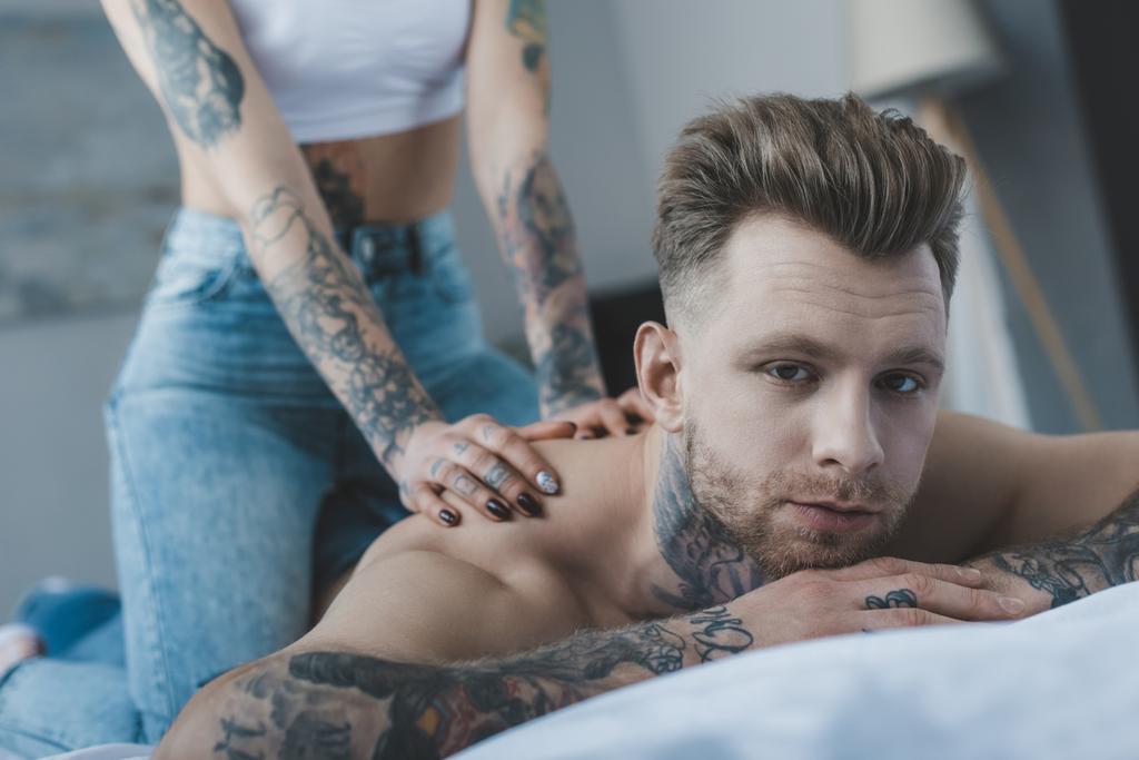 vista ritagliata della fidanzata tatuata che fa massaggi per il suo ragazzo
 - Foto, immagini