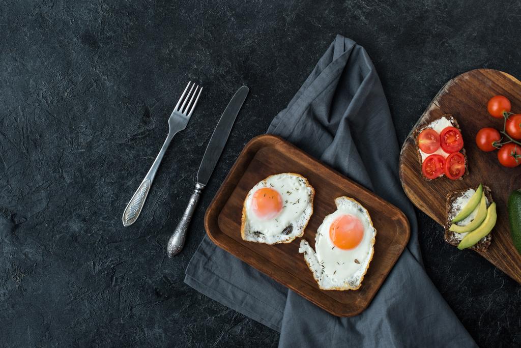 top view of fried eggs and healthy snacks for breakfast on dark tabletop - Photo, Image