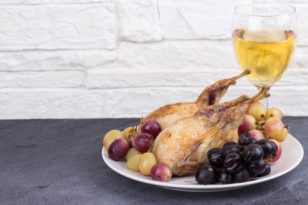 Baked quails with grapes and a glass of wine - Photo, Image