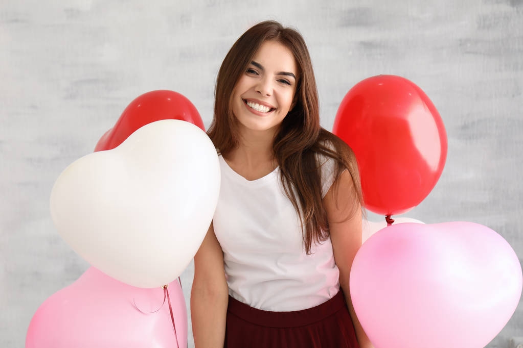 giovane donna con palloncini a forma di cuore
 - Foto, immagini