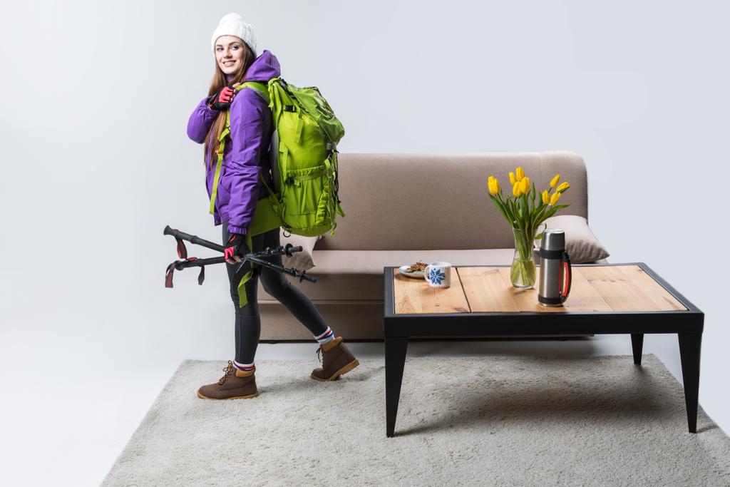 красивая спортсменка в теплой одежде с рюкзаком и туристическим оборудованием, готовая к путешествию
 - Фото, изображение