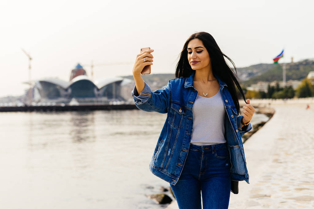 stylové černé vlasy dívka prochází Ázerbájdžán, procházky po městě Baku a dělá selfie - Fotografie, Obrázek