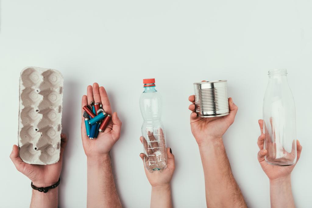 частковий вид групи людей, що тримають різні види сміття ізольовані на сірому
 - Фото, зображення