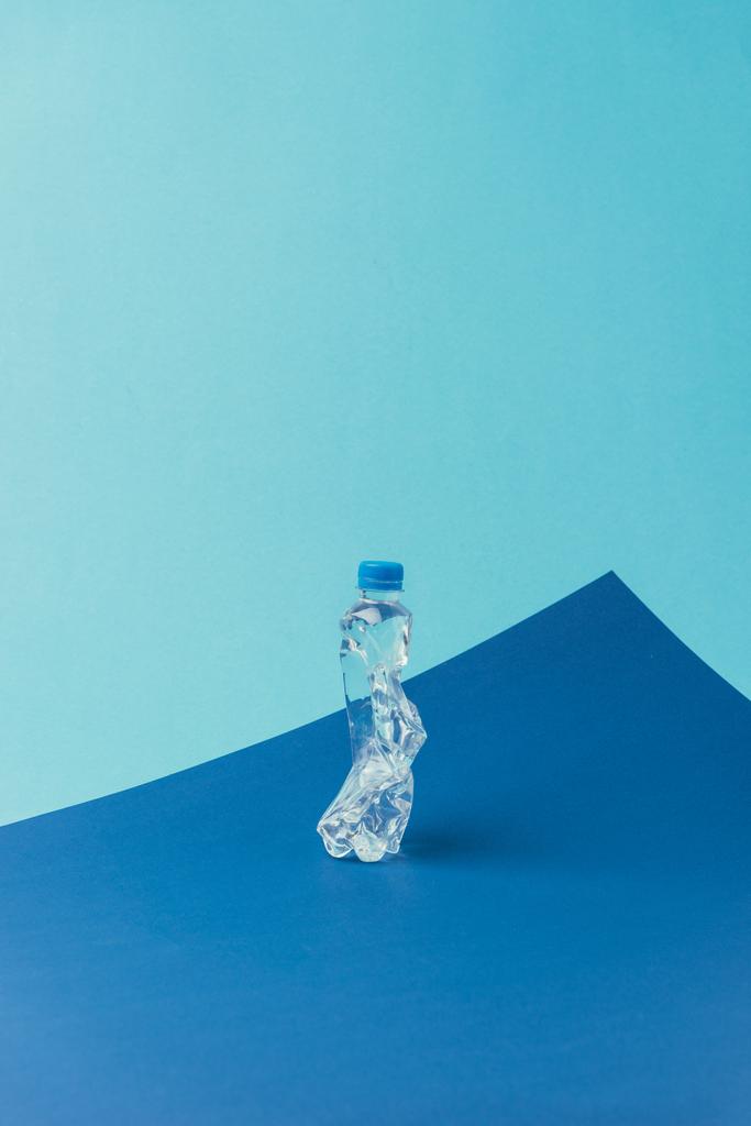 Close-up van plastic fles op blauwe achtergrond, recycle concept - Foto, afbeelding