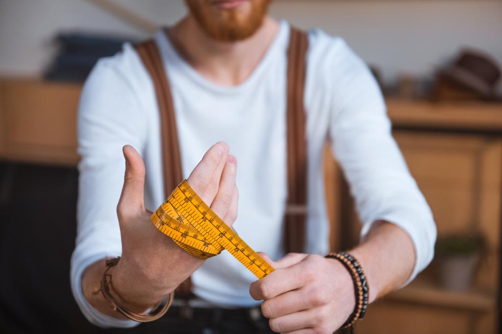 Detailní pohled mladých mužů módní návrhářka drží měřicí páska - Fotografie, Obrázek