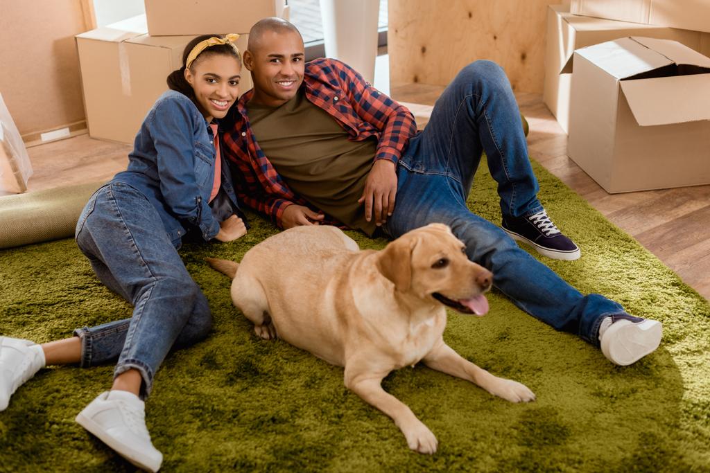 Африканская американская пара с собакой-лабрадором переезжает в новую квартиру
 - Фото, изображение