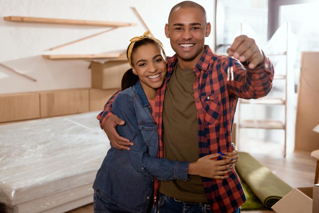 feliz pareja afroamericana sosteniendo llaves en nuevo apartamento
  - Foto, Imagen