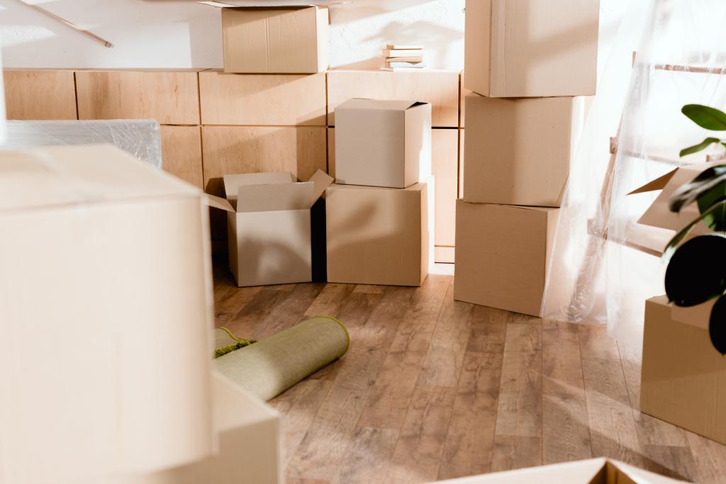 rolled carpet and cardboard boxes in new apartment, moving concept - Photo, Image