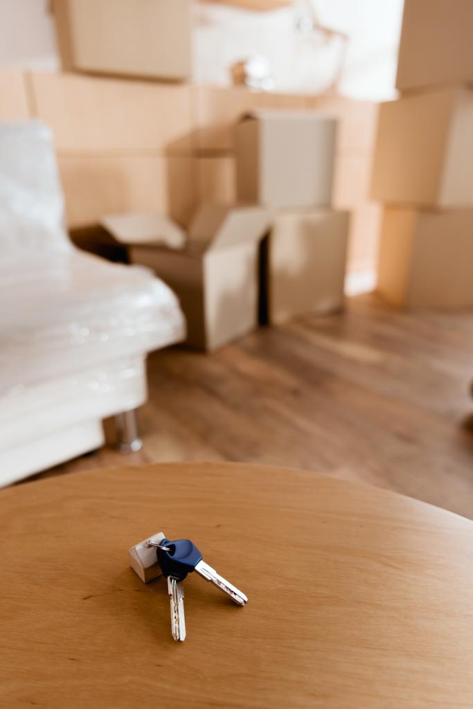 keys on table in new apartment with cardboard boxes, moving concept - Photo, Image