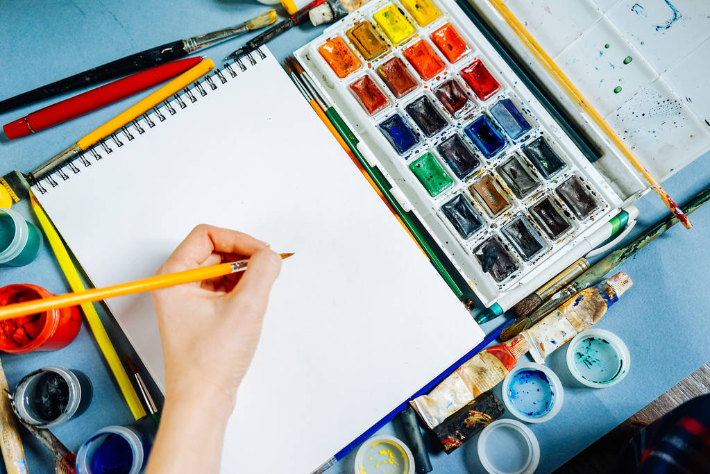 Frau malt Künstlerin mit Pinsel und Aquarellfarbe auf weißem Papier - Foto, Bild