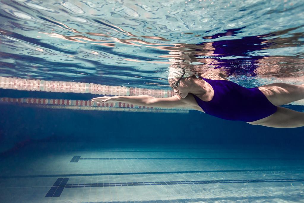 подводная фотография молодой женщины, занимающейся плаванием в бассейне
 - Фото, изображение