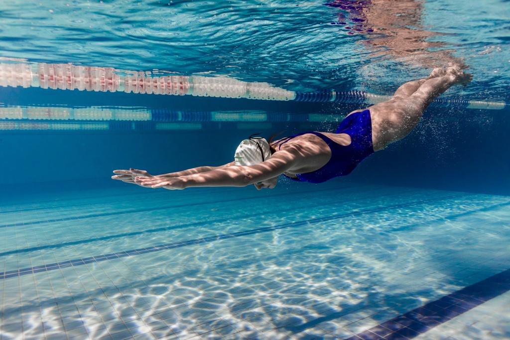 підводне зображення жіночого плавця у плавальному костюмі та тренуванні окулярів у басейні
 - Фото, зображення