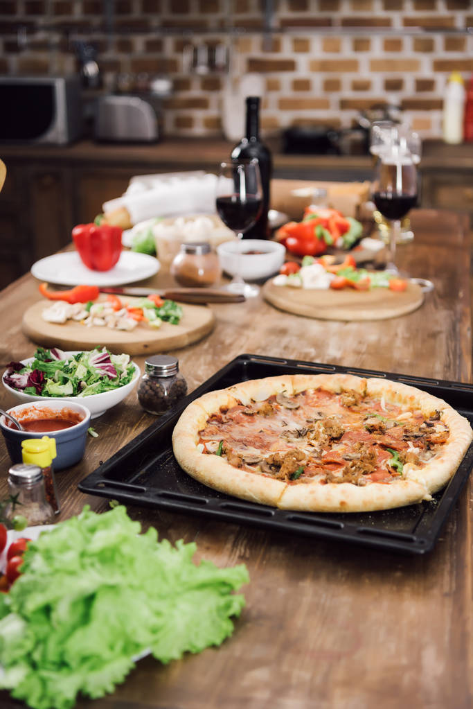 hausgemachte leckere Pizza auf dem Tisch in der Küche - Foto, Bild