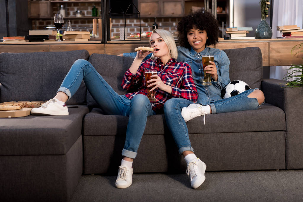 muchachas multiculturales viendo fútbol en la televisión con cerveza
 - Foto, Imagen