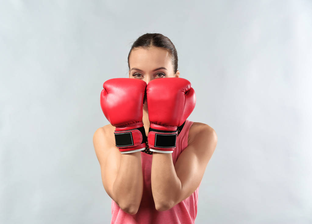 Mujer fuerte en guantes de boxeo sobre fondo gris
 - Foto, Imagen