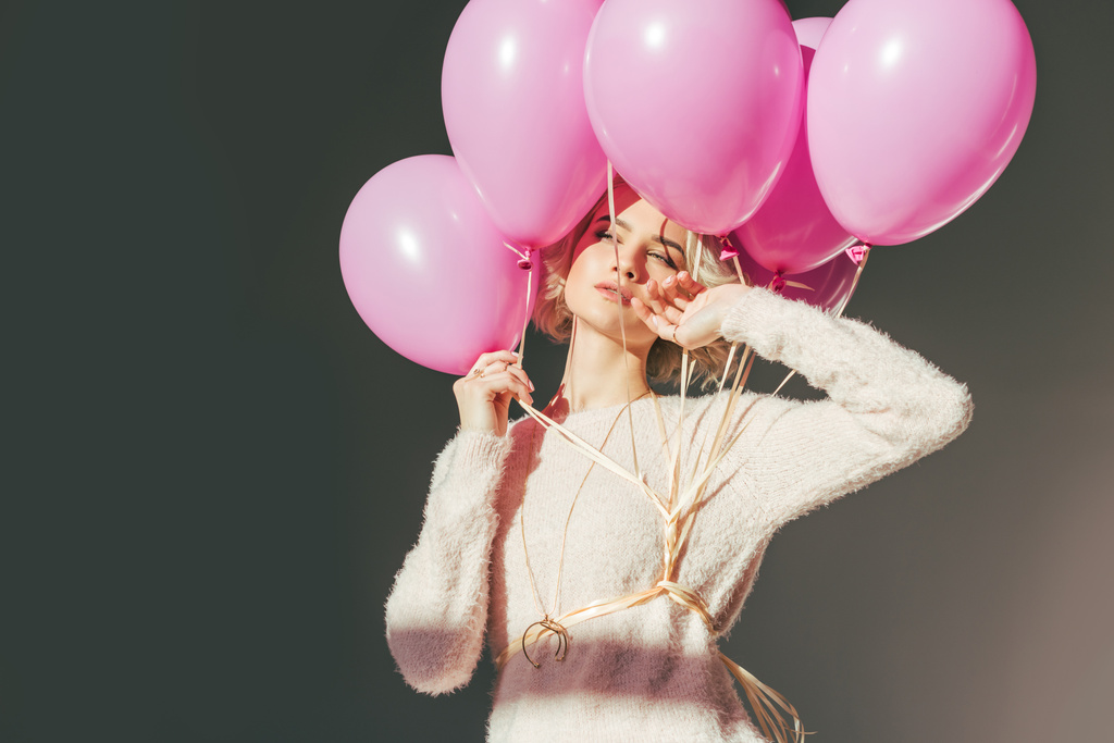 sensual young woman posing with pink balloons isolated on grey - Photo, Image