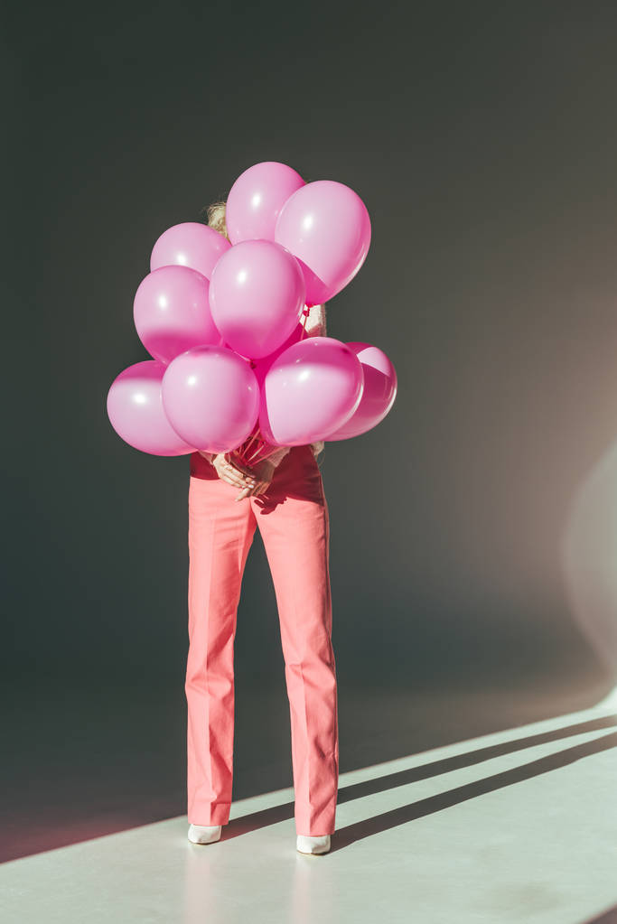 κομψή γυναίκα κρατώντας ροζ μπαλόνια για διακοπές - Φωτογραφία, εικόνα