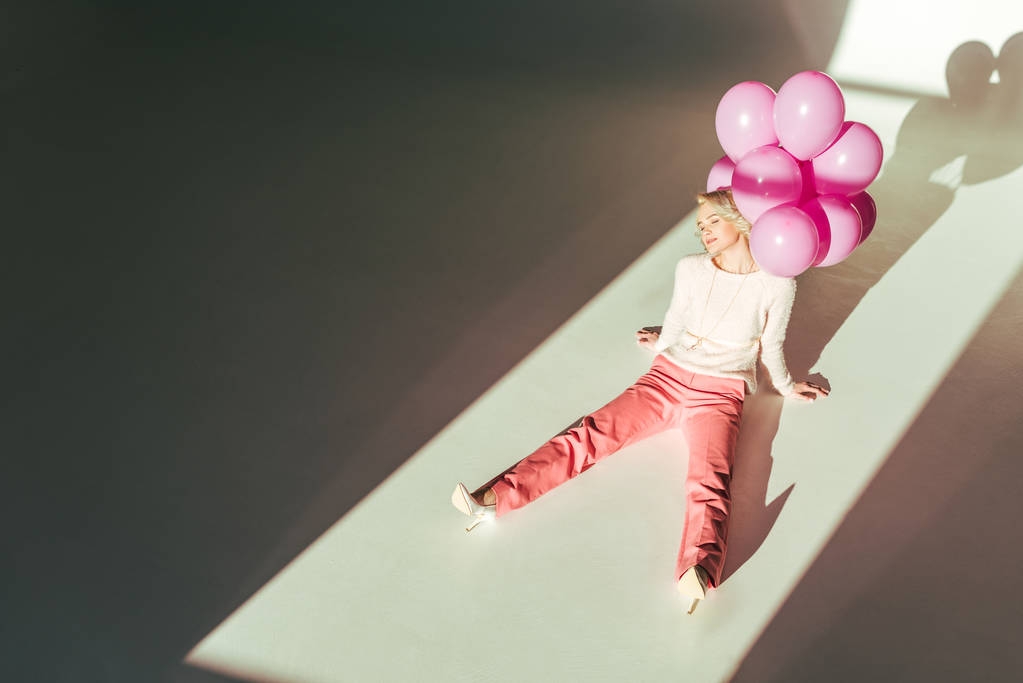 mooie stijlvolle vrouw zittend met roze ballonnen - Foto, afbeelding