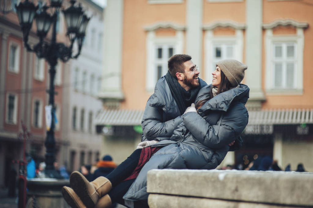 Счастливая молодая пара обнимается на зимних каникулах в городе
 - Фото, изображение
