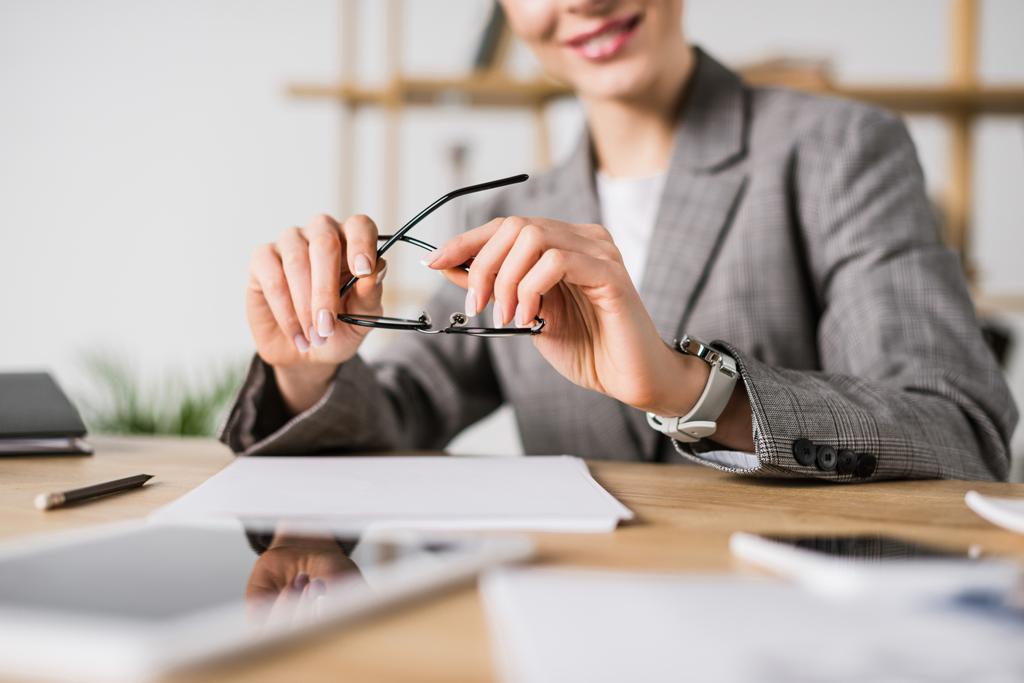 частковий вид бізнес-леді з окулярами на робочому місці з документами
 - Фото, зображення