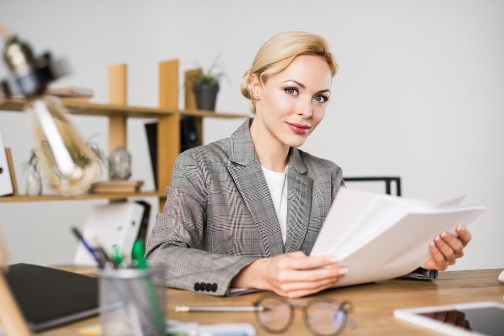 portrait of businesswoman doing paperwork at workplace in office - Photo, Image