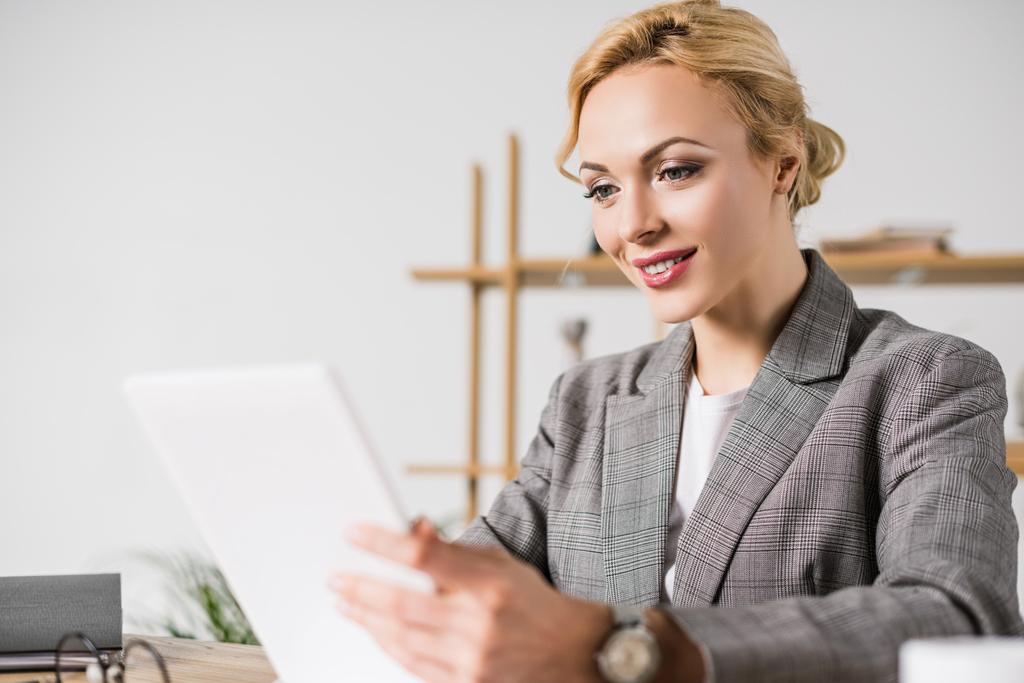 donna d'affari sorridente con tablet digitale sul posto di lavoro in ufficio
 - Foto, immagini
